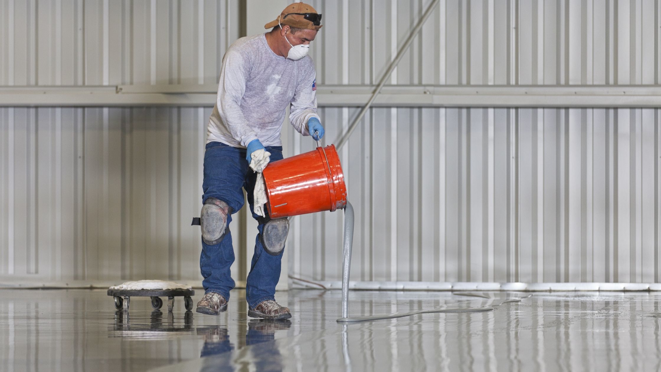 GettyImages-185001193 man pouring resinous floor coating