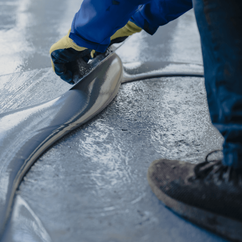 Person smoothing out epoxy resinous flooring