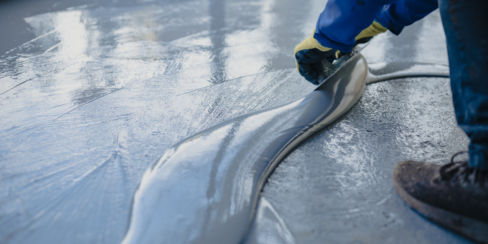 Person smoothing out epoxy resinous flooring